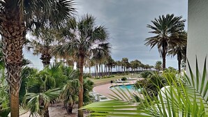 Ein Poolbereich mit Palmen und Blick auf den Ozean.