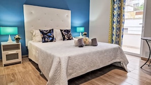 A bedroom with a large bed, two bedside tables, a nightstand, a window with curtains, and a view of the outside. - Cristal VIP Properties by Interhome (Albufeira)