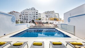 A rooftop pool with clear blue water, surrounded by white buildings with balconies. - Cristal VIP Properties by Interhome (Albufeira)