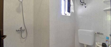 Un baño con ducha, inodoro y lavamanos.
