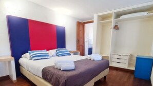 Een keurig opgeruimde slaapkamer met een bed, nachtkastjes, een kledingkast en een inloopkast.