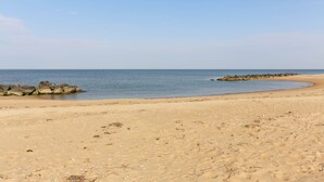 A sandy beach with calm water and a clear sky. - Waterfront Willoughby Oasis (Norfolk)