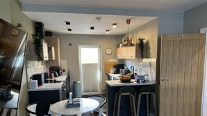 Une cuisine moderne dotée d’un îlot central, de tabourets de bar et d’une table à manger.