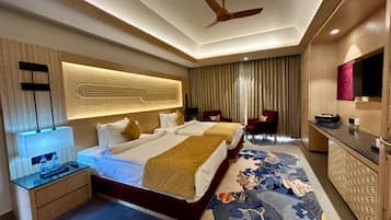 A hotel room with a bed, bedside tables, a desk, a chair, a ceiling fan, and a large mirror.