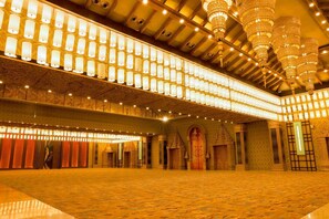 A spacious hall with a patterned floor, ornate chandeliers, and a series of illuminated lamps. - Ananta Spa & Resorts Jaipur (Jamwa Ramgarh)