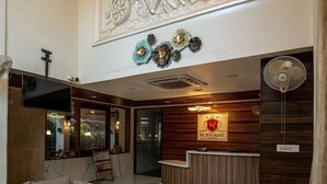 A hotel lobby with a reception desk, sofas, a coffee table, and a decorative ceiling mural. - M Square Hotel-hitec City (Hyderabad)