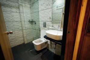 Un baño con inodoro, lavamanos y ducha.