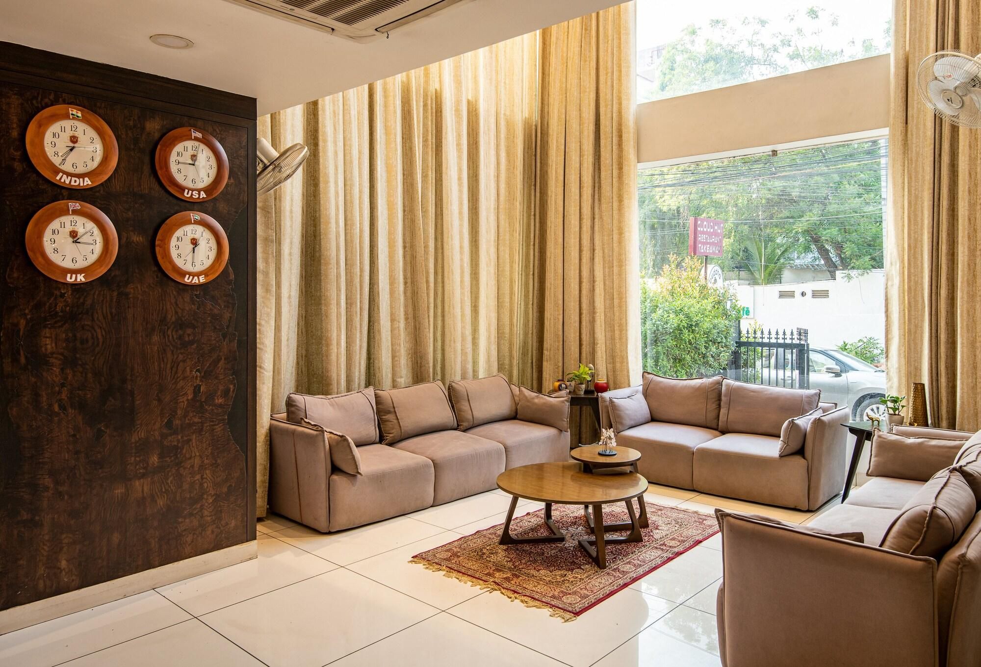 A living room with a sectional sofa, a coffee table, and a wall clock displaying time from four different countries.
