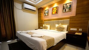 A modern hotel room with a large bed, a bedside table, an air conditioning unit, and artwork on the wall. - M Square Hotel-hitec City (Hyderabad)
