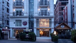 A multi-story hotel with balconies, a restaurant, and a sign indicating it is a luxury A/C 300m & banquet hotel. - M Square Hotel-hitec City (Hyderabad)