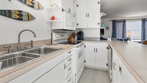 Une cuisine moderne avec des meubles blancs, un évier à deux bacs et une cuisinière.