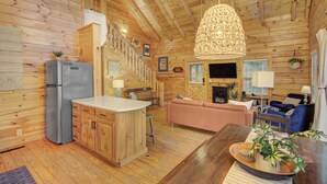 Een houten hut van binnen met een keuken, een eetgedeelte en een woonkamer.