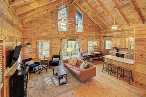 L’intérieur d’une cabane en rondins comprend un salon, une cuisine et un coin repas.