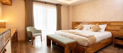 Un dormitorio con una cama de madera, un banco, un escritorio y una silla.