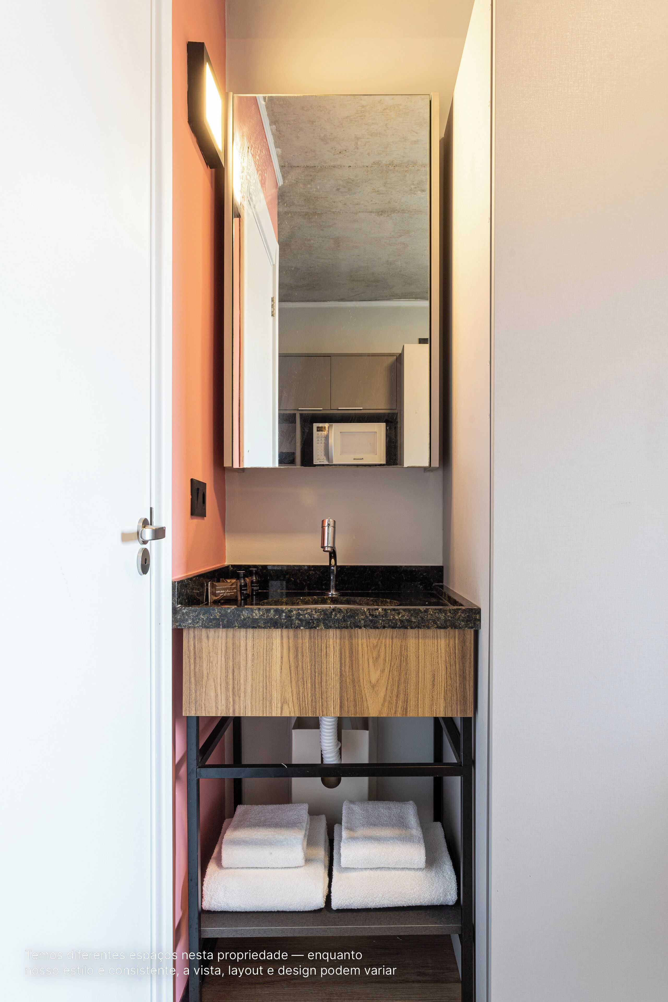 A bathroom with a wooden vanity, a sink, and a towel rack.