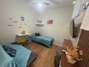 A bedroom with two beds, a desk, a chair, and a TV. - Apartamento na Praia do Forte 😉 , Centro Cabo Frio - RJ 118 (Centro Cabo Frio)