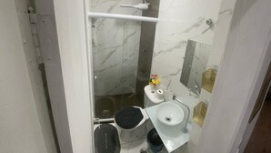 A compact bathroom with a toilet, bidet, and sink. - Apartamento na Praia do Forte 😉 , Centro Cabo Frio - RJ 118 (Centro Cabo Frio)