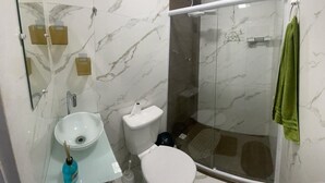 A bathroom with a glass-enclosed shower, a sink, and a toilet. - Apartamento na Praia do Forte 😉 , Centro Cabo Frio - RJ 118 (Centro Cabo Frio)