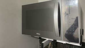 A Philco microwave oven mounted on a stand. - Apartamento na Praia do Forte 😉 , Centro Cabo Frio - RJ 118 (Centro Cabo Frio)
