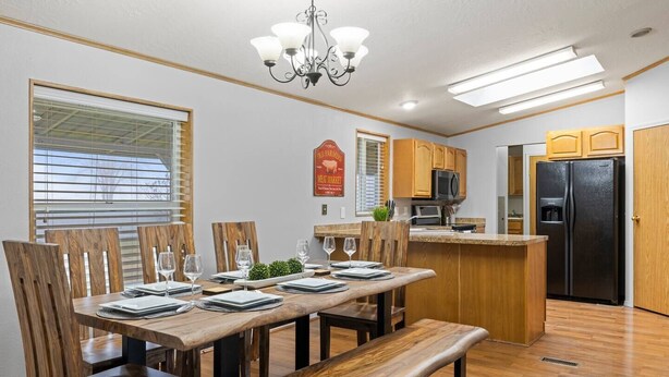 A modern kitchen with wooden cabinetry, a built-in island, and a black refrigerator. - Big Parking Lot, Pets Invited, Fenced Farm Home (Kennewick)