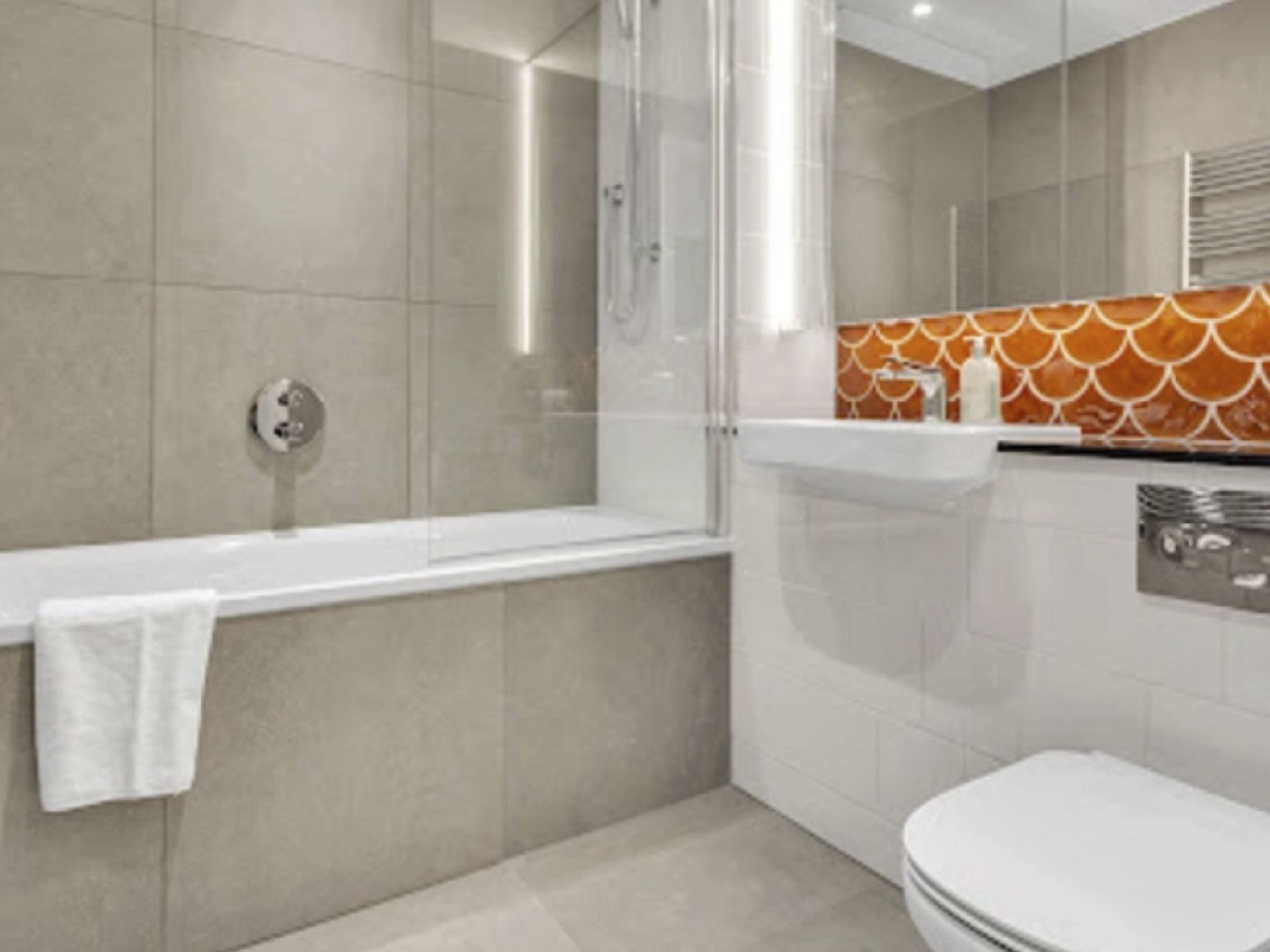 A modern bathroom with a bathtub, toilet, and shower area.
