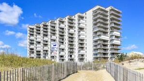 A multi-story residential building with a sandy pathway leading to the entrance. - Sea Terrace 88th St, Outdoor Pool, Oceanfront building & View, *FREE Linen Pkg* (Ocean City)