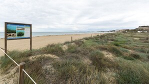 A beach with a wooden fence and a signboard. - LES GAVINES - Charming apartment with sea views - Free Wifi (Dénia)