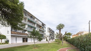 A multi-story residential building with balconies, a paved walkway, and a well-maintained lawn. - LES GAVINES - Charming apartment with sea views - Free Wifi (Dénia)