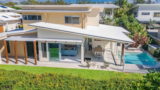 A modern two-story house with a covered patio, a swimming pool, and a well-maintained garden. - Coastal charm on Casuarina Way with a pool! (Tweed)