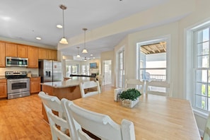 A spacious kitchen with wooden cabinets, stainless steel appliances, and a large island with seating.