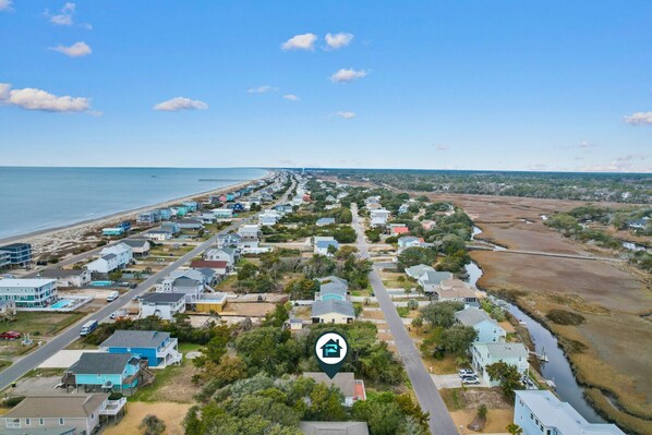 Zona residencial costera con casas, una playa y un río.