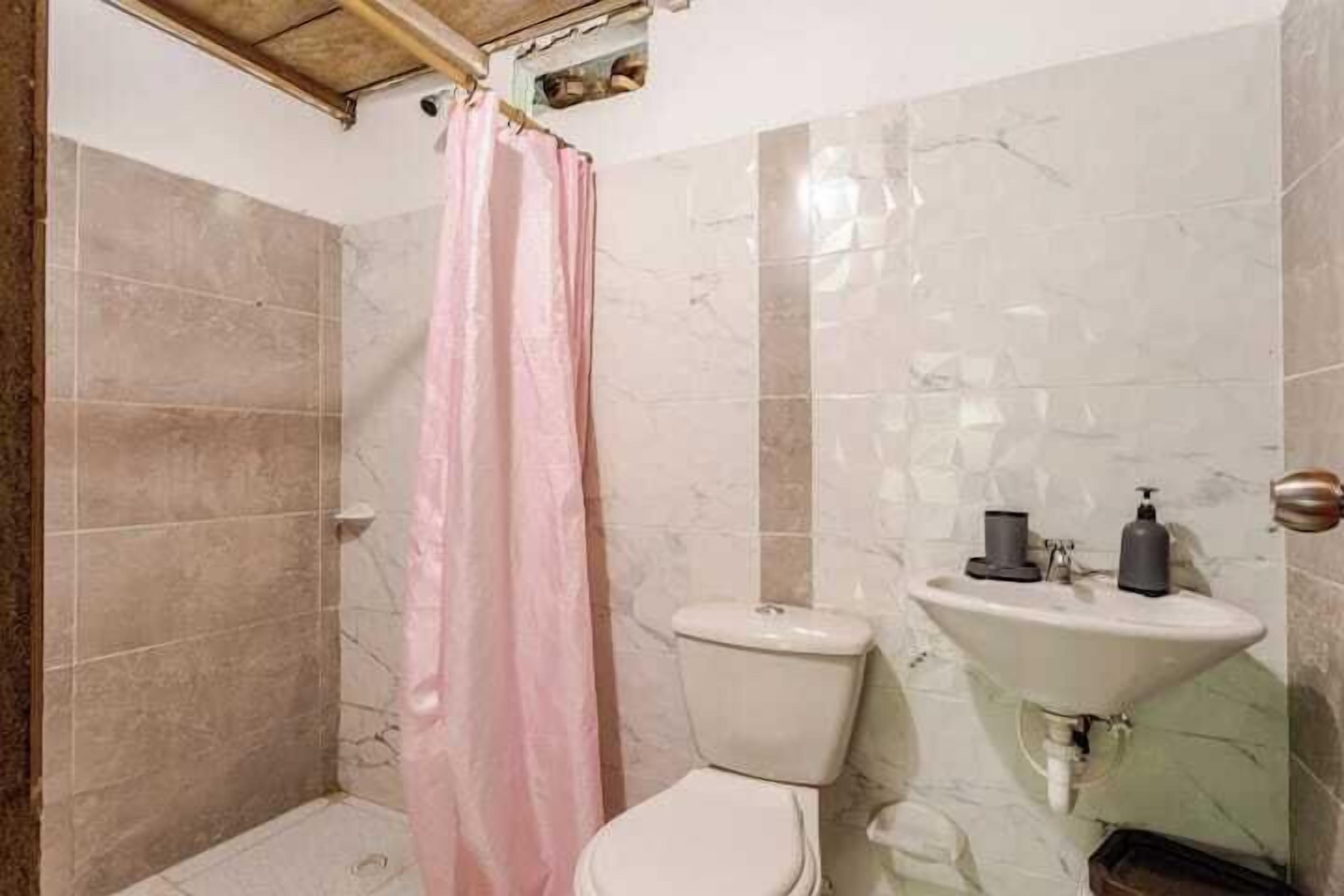 Ein Badezimmer mit Dusche, Toilette und Waschbecken.