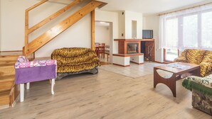A living room with a wooden staircase, a fireplace, and two sofas.