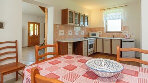 A compact kitchen with wooden cabinets, a microwave, and a sink.