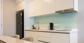 Business appartement | Privékeuken | Een koelkast, een kookplaat, kookgerei, borden en bestek