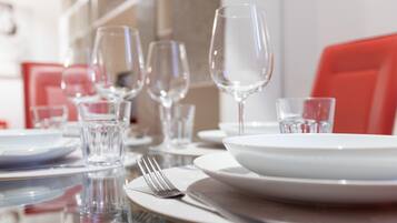 Une table à manger dressée avec des assiettes, des verres et des couverts.