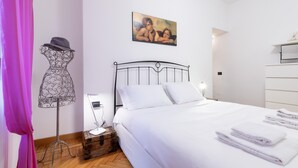 A bedroom with a bed, a dresser, a painting, a mannequin, and a suitcase. - Italianway Easy - Masotto 4 (Milan)