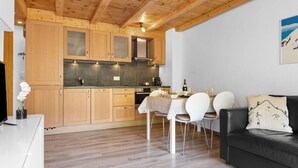 A modern kitchen with wooden cabinets and a dining area with a table and chairs.