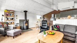 A modern living room with a fireplace, a sofa, a coffee table, and a bookshelf.