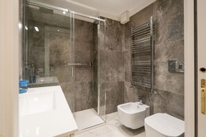 Een douche, een haardroger, een bidet, handdoeken
