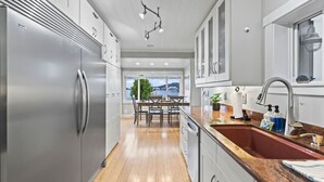 Eine moderne Küche mit Edelstahlgeräten, einer Granitabdeckung und Seeblick.