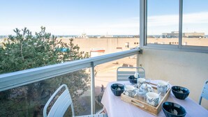 A balcony with a table set for dining, overlooking a marina and buildings. - Port Arcachon by Interhome (Arcachon)