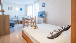 Une chambre d’hôtel moderne équipée d’un lit, d’un bureau, d’une télévision et d’un coin repas.