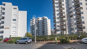 Un immeuble d’appartements moderne, doté de plusieurs étages, de balcons et surplombant un ciel d’un bleu éclatant.