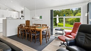 Un intérieur moderne comprenant un coin repas, une cuisine et un espace salon.