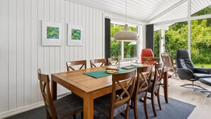 Un coin repas avec une table en bois, des chaises et des œuvres d’art accrochées au mur.