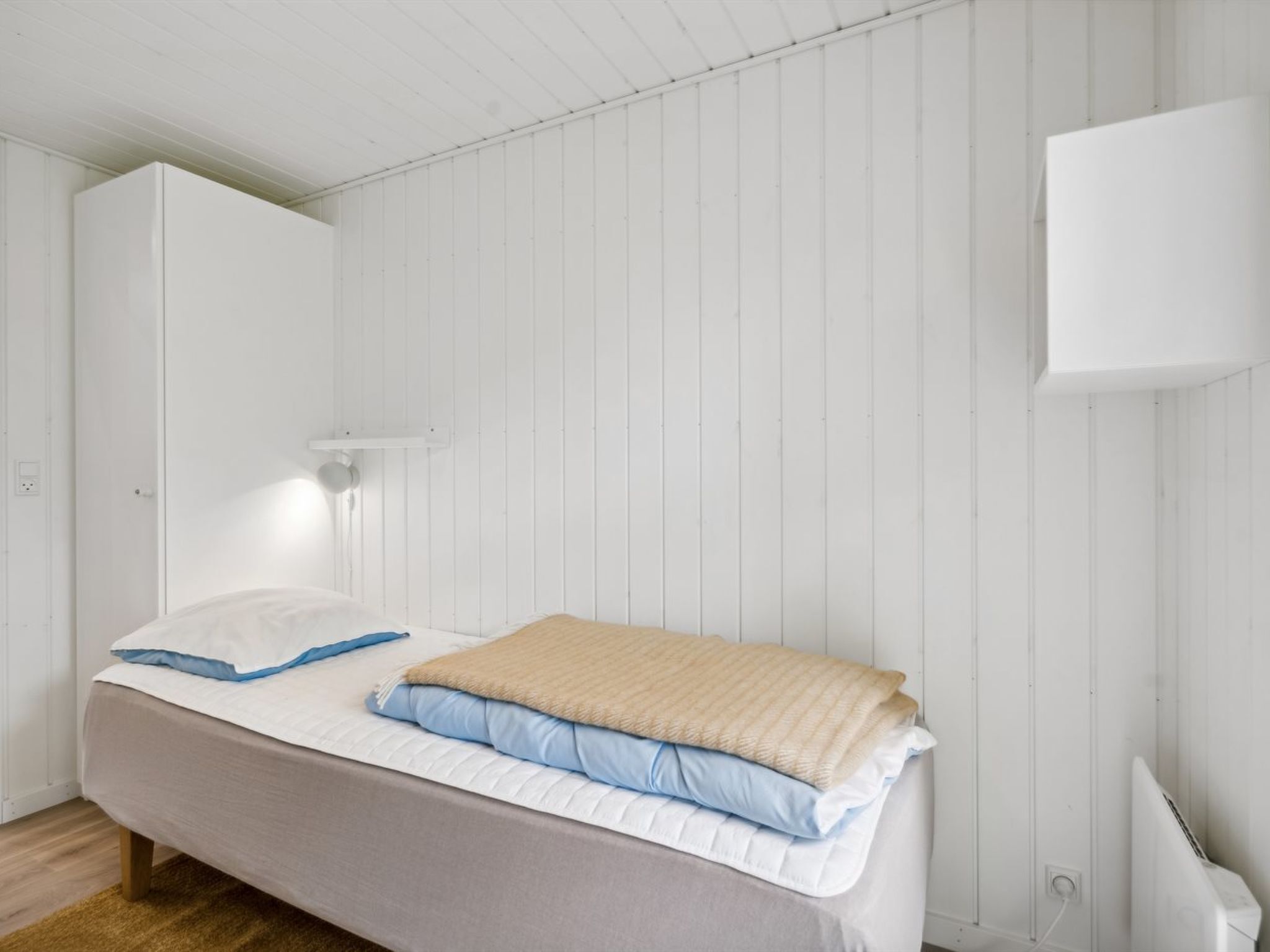 Una camera da letto con un letto, un armadio e un condizionatore d'aria a parete.
