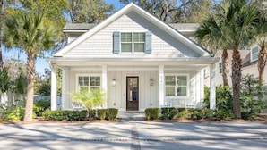 A two-story house with a front porch, a dark front door, and a mailbox.