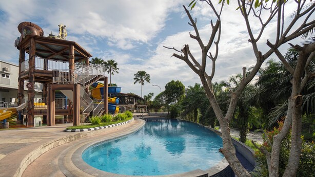 A swimming pool with a slide and a play structure.
