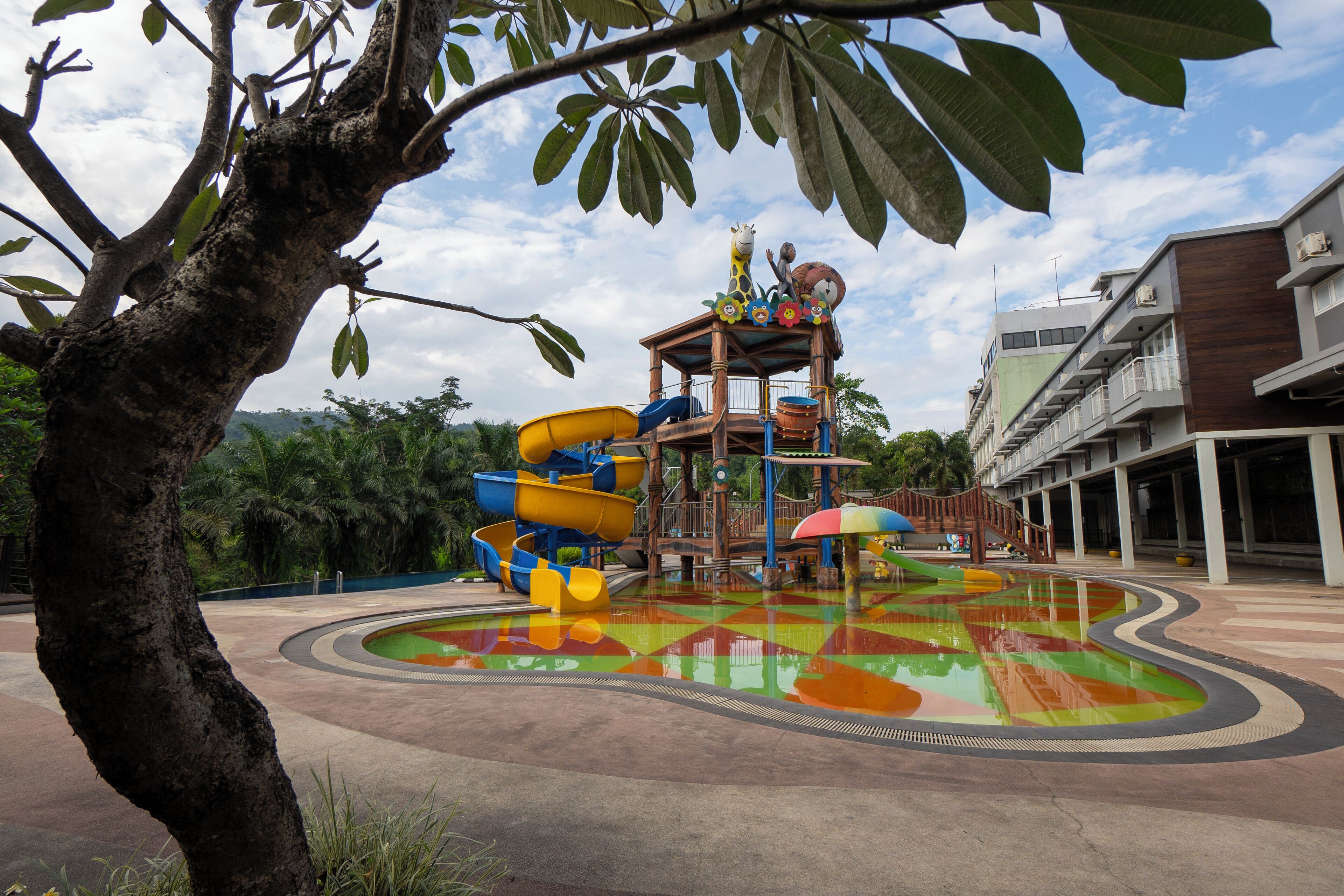 Un parque acuático con una zona de juegos colorida, que incluye toboganes y una piscina.